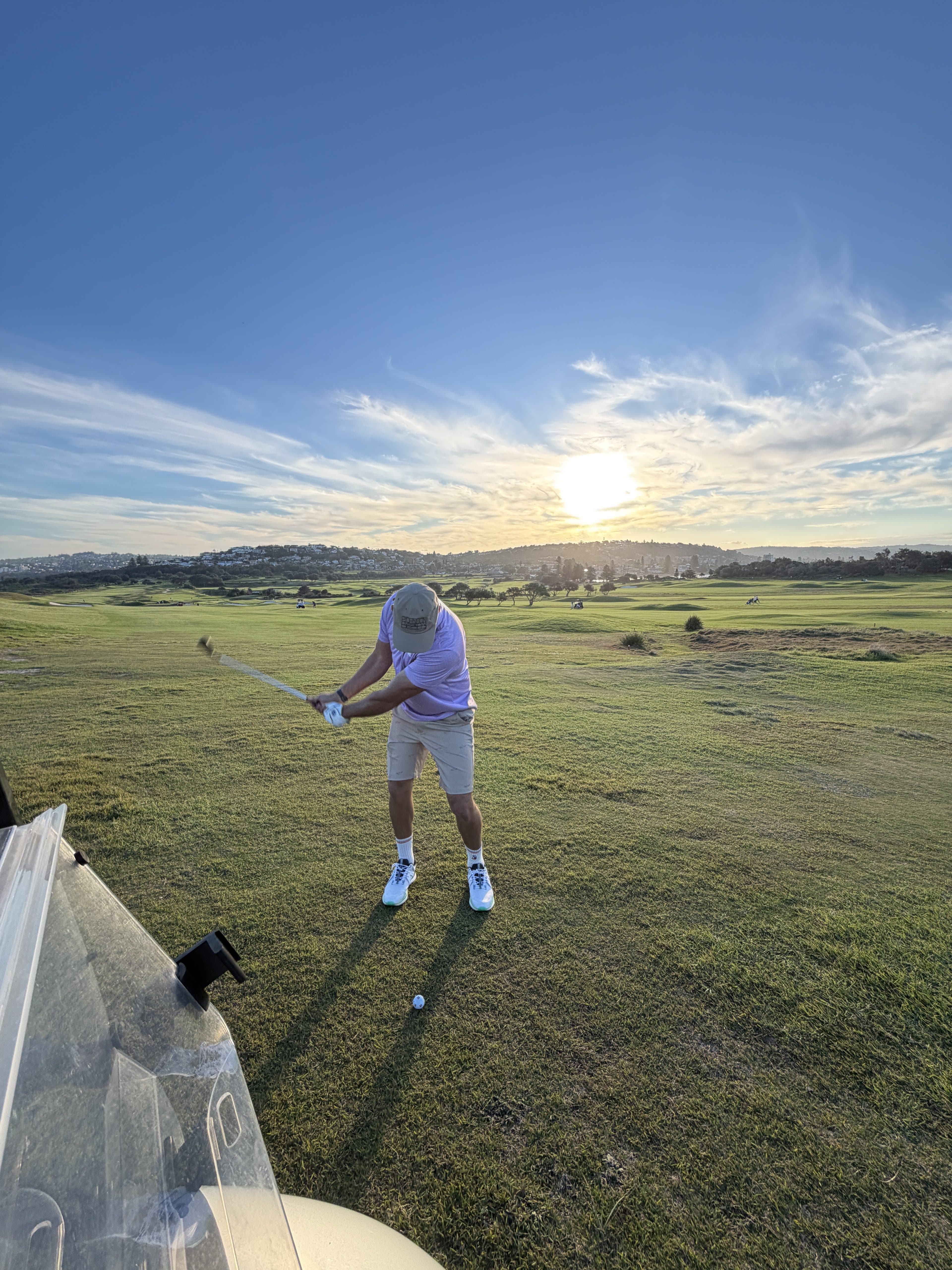 One of the crew mid-swing on the fairway at Long Reef, late afternoon